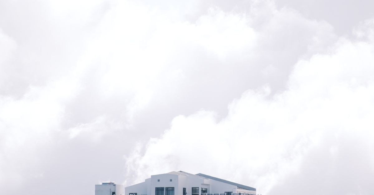 Simple modern building against a cloudy sky, offering ample copy space.